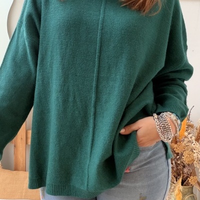 Mulher a usar camisola verde de gola alta e jeans com bordados florais