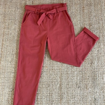 Calças vermelhas com cinto sobre tapete de malha cru