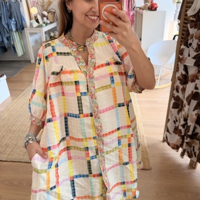 Camisa feminina colorida com padrão xadrez e detalhes florais