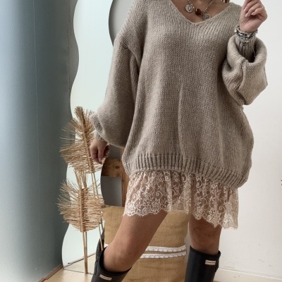 Mulher com camisola bege oversized, vestido de renda e botas pretas Hunter