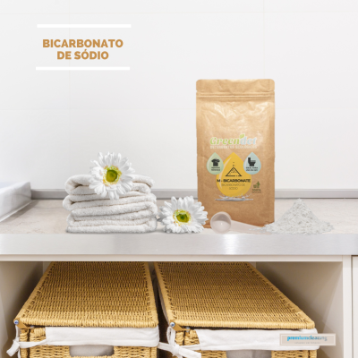 Embalagem de bicarbonato de sódio GreenJet com toalhas e flores ao lado numa prateleira branca