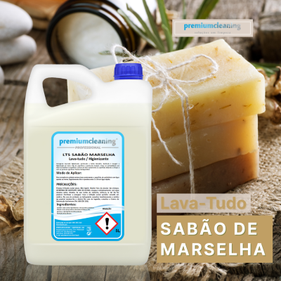 Recipiente branco de sabão líquido com etiqueta azul e sabões de Marselha empilhados amarrados com corda sobre mesa de madeira