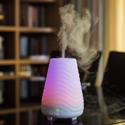 Difusor de aromaterapia branco com luz colorida e vapor saindo do topo