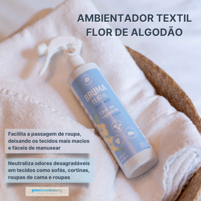 Spray ambientador têxtil branco com rótulo azul claro em toalhas brancas sobre estera de palha