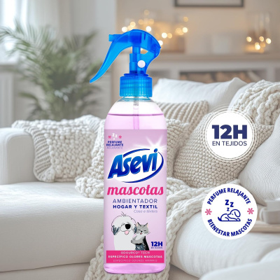 Frasco de ambiente Asevi mascotes rosa com pulverizador azul sobre sofá com mantas claras