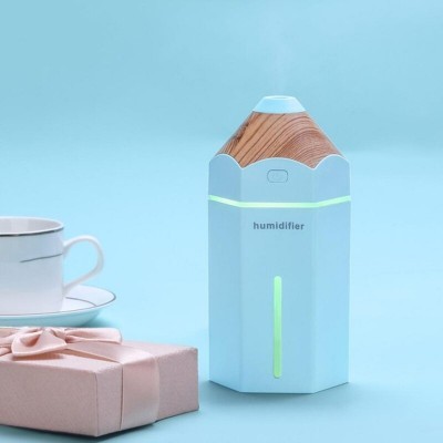 Humidificador branco com tampa em padrão madeira, forma de lápis, linha verde, com presente rosa e chávena branca ao lado