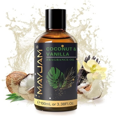 Frasco de óleo aromático May Jam de 100mL com rótulo preto e texto verde e dourado, coco partido e flores de baunilha ao fundo