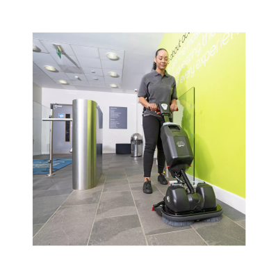 Máquina de limpeza a limpar chão de ladrilhos cinza numa divisão interior com parede verde