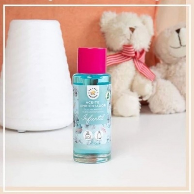 Frasco de ambientador infantil azul com tampa rosa junto a difusor e ursinhos de pelúcia