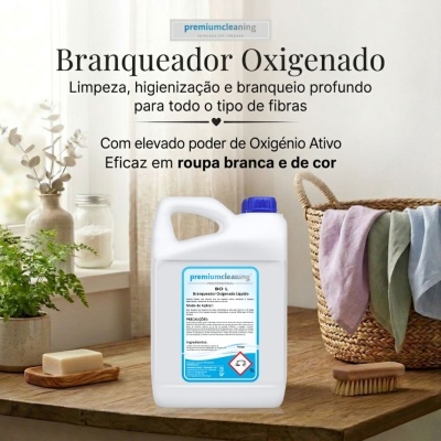 Recipiente branco com tampa azul do branqueador oxigenado líquido da premiumcleaning sobre mesa de madeira com cesta de roupa ao lado.