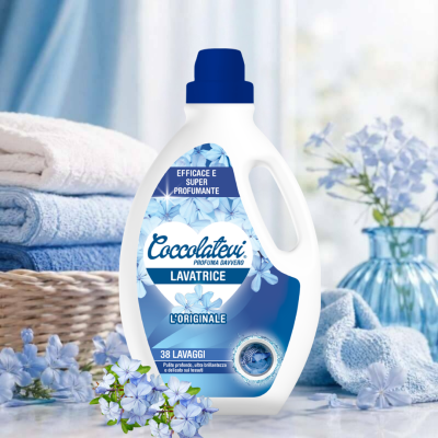 Detergente para máquina de lavar roupa Coccolatevi com rótulo azul e flores, junto a toalhas e flores azuis