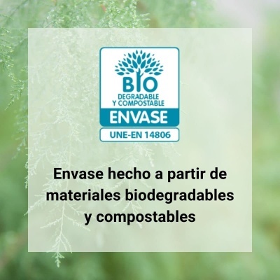 Selo biodegradável e compostável com texto em espanhol sobre fundo verde desfocado