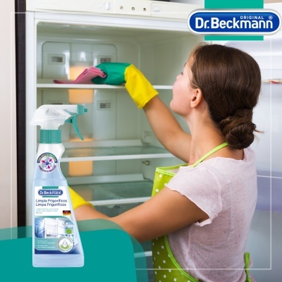 Produto de limpeza para frigoríficos Dr.Beckmann com mulher a limpar um frigorífico aberto.