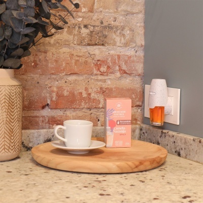 Chávena e caixa de chá Calmala Naranja Spicy sobre prato de madeira num balcão de cozinha