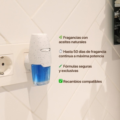 Difusor de fragrâncias elétrico branco com reservatório azul numa tomada com azulejos brancos ao fundo