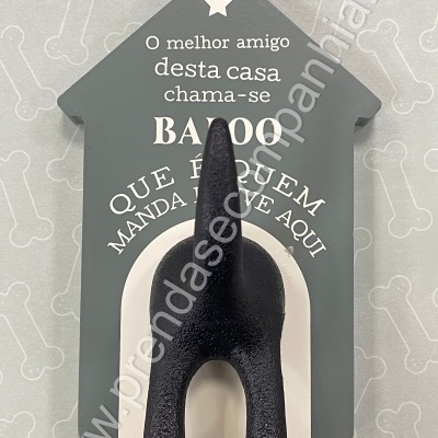 Placa decorativa cinza em forma de casa com cauda de cão preta e texto em branco