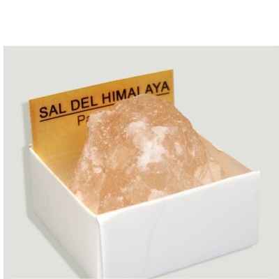 Bloco de sal rosa do Himalaia numa caixa branca com cartão amarelo ao fundo