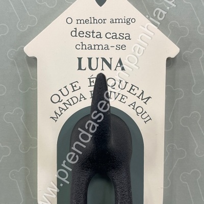 Decoração branca em forma de casinha com texto em português e cauda preta de cão em relevo