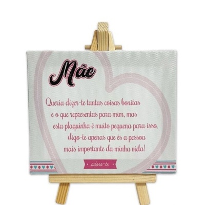 Placa decorativa branca com texto em português e padrão de corações, em cavalete de madeira.