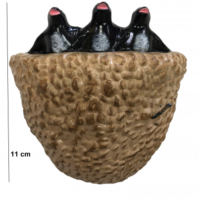 Escultura de três toupeiras pretas com focinhos rosas numa base castanha texturizada.