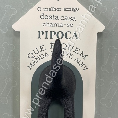 Objeto decorativo em forma de casinha branca com texto e figura de cauda de cão preta