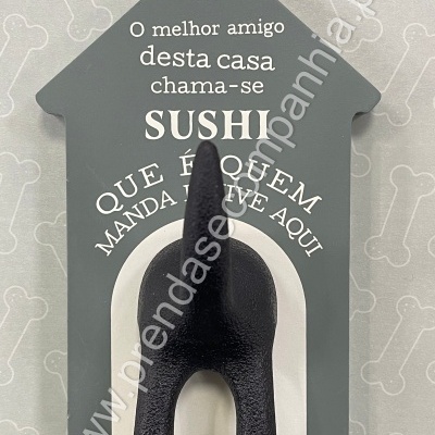Placa decorativa cinzenta com texto branco e rabo de cão preto em destaque