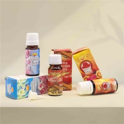 Frascos de fragrâncias com caixas coloridas em superfície bege.