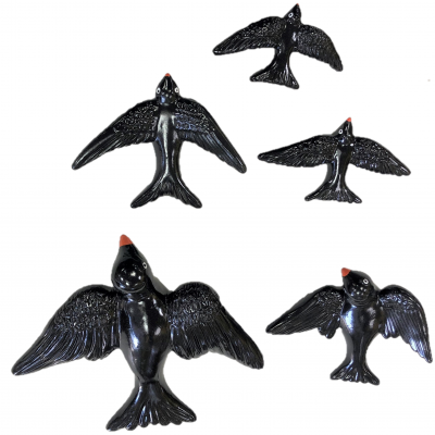 Figuras decorativas de pássaros pretos com bicos vermelhos, vistas de cima sobre fundo branco.