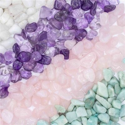 Pedras de cristal polidas em branco, roxo, rosa e verde claro, organizadas em faixas