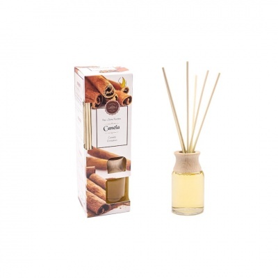 Difusor de aromas com frasco de vidro e varetas ao lado da caixa com imagens de canela