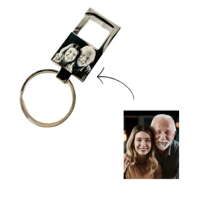 porta-chaves prateado com abre-garrafas e imagem gravada a preto e branco de duas pessoas