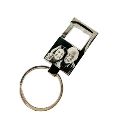 Porta-chaves metálico com relevo de duas pessoas sorrindo