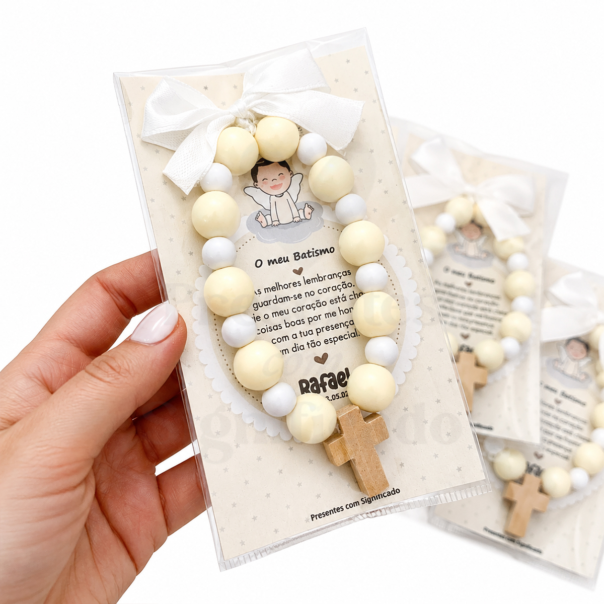 Lembranças (Dezenas redondas - BEGE) Pulseira com contas creme e brancas, cruz de madeira e cartão decorativo para batismo