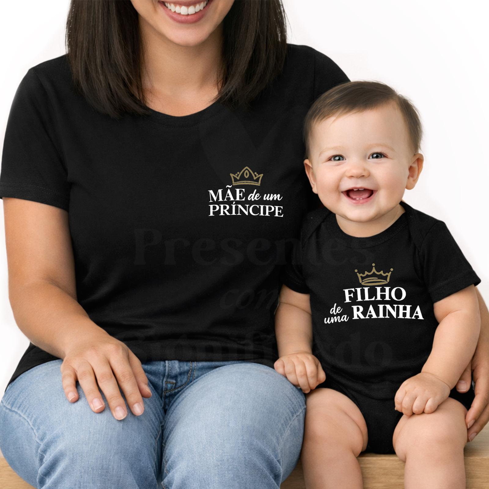 Conjunto Mãe e Filho(a) Personalizado - Mãe de um/dois príncipe(s) Conjunto de roupa preto para mãe e filho com textos em branco e dourado e coroas, mãe com t-shirt e bebé com body sentado num banco.