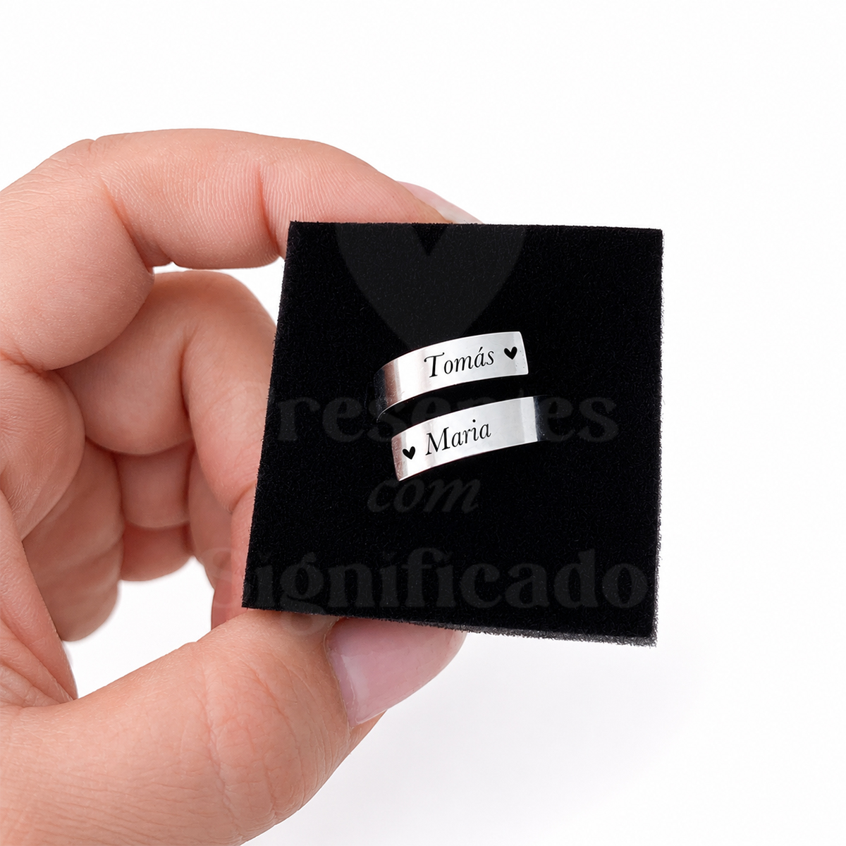 Anel espiral personalizado Dois anéis prateados com nomes gravados Tomás e Maria num suporte preto