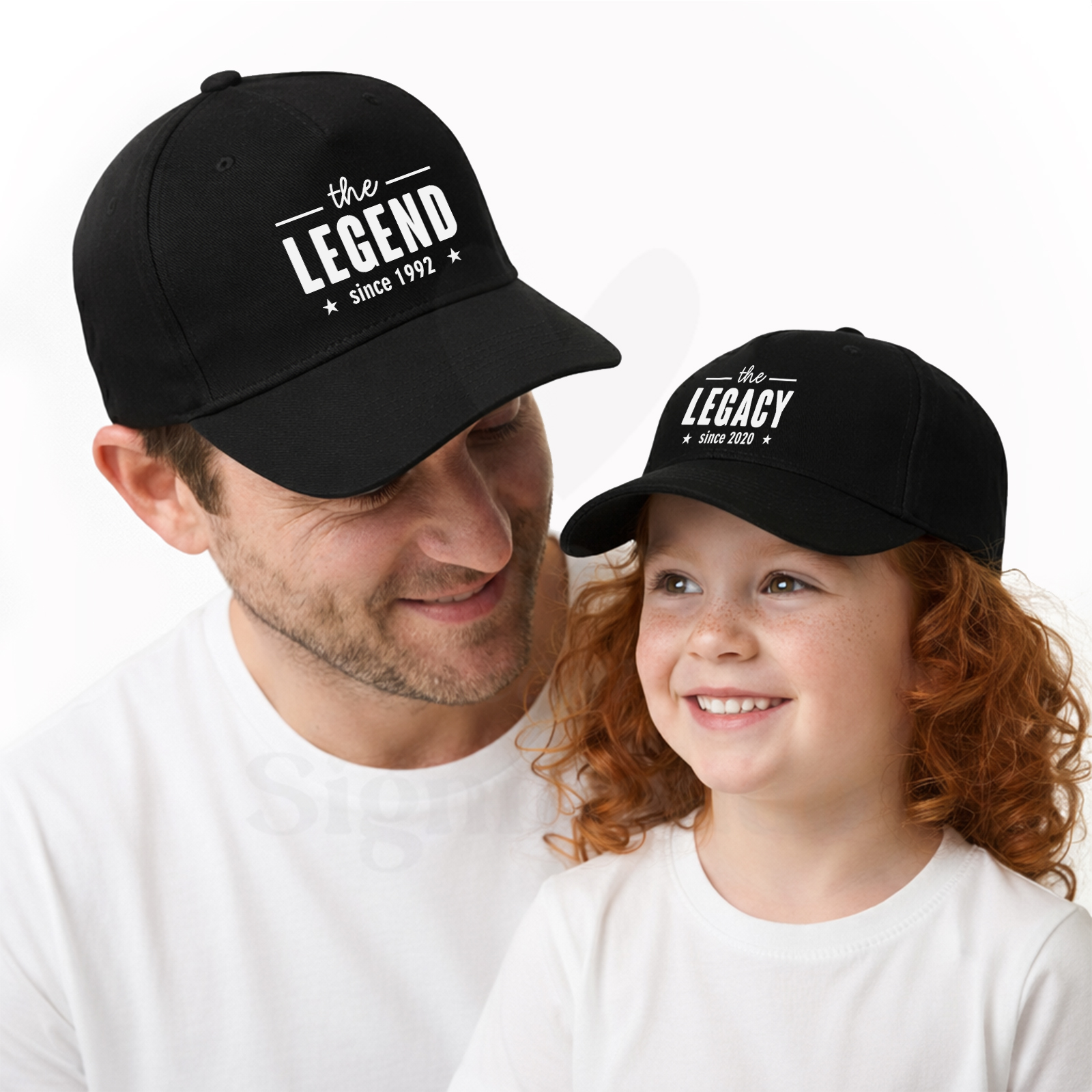 Conjunto de bonés - The Legend / The Legacy Homem e criança com bonés pretos com texto branco e camisetas brancas em fundo branco.