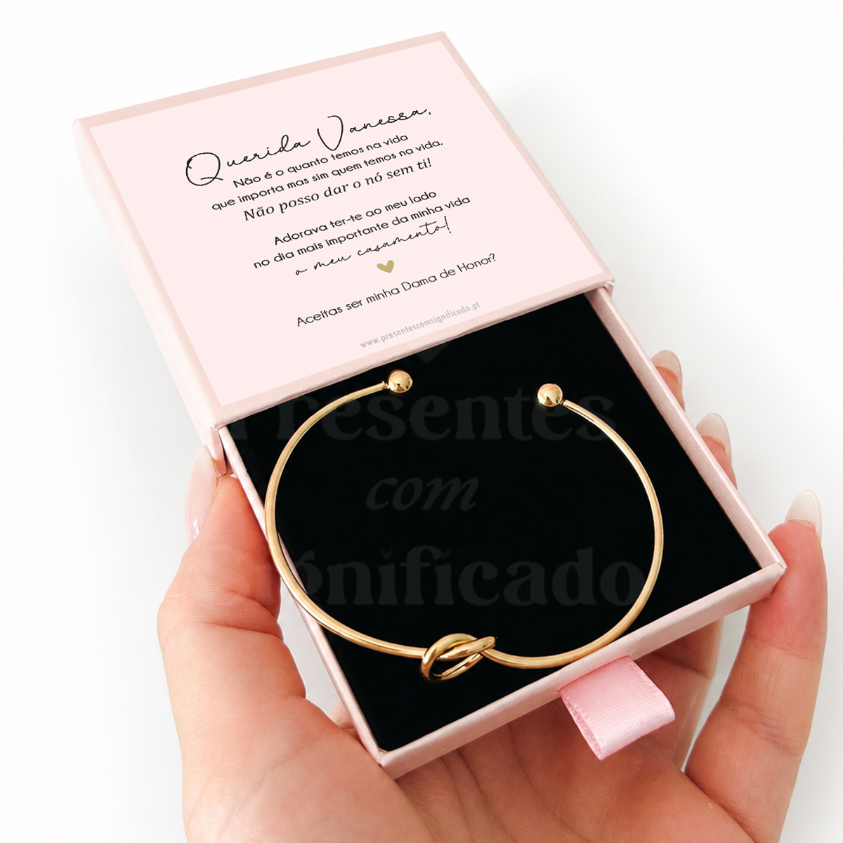 Escrava em aço com nó (com caixa) Pulseira dourada com nó em caixa rosa com texto a perguntar se aceita ser dama de honra