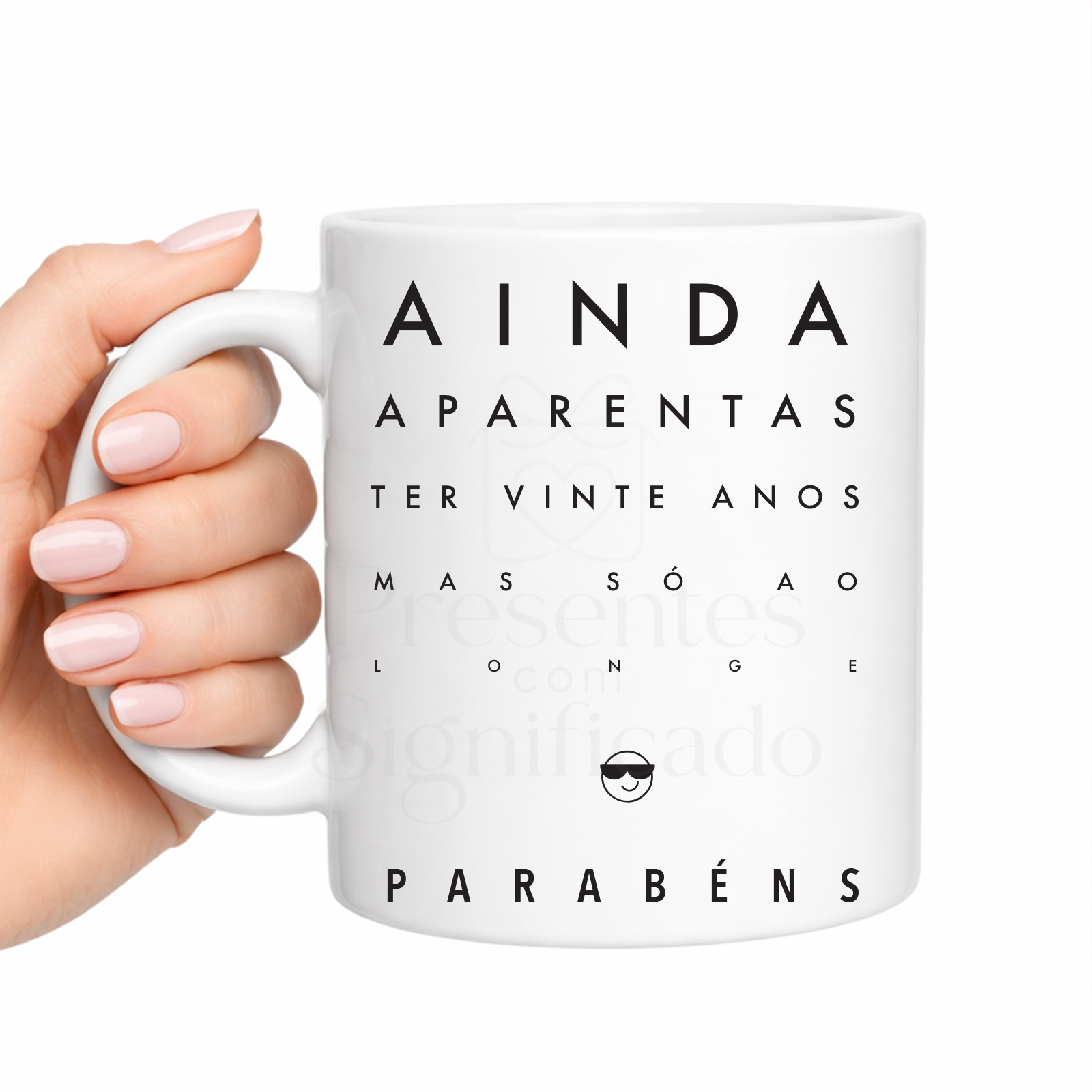 Caneca de Aniversário — Ainda Aparentas Ter Vinte Anos Caneca branca com texto preto e emoji sorridente com óculos