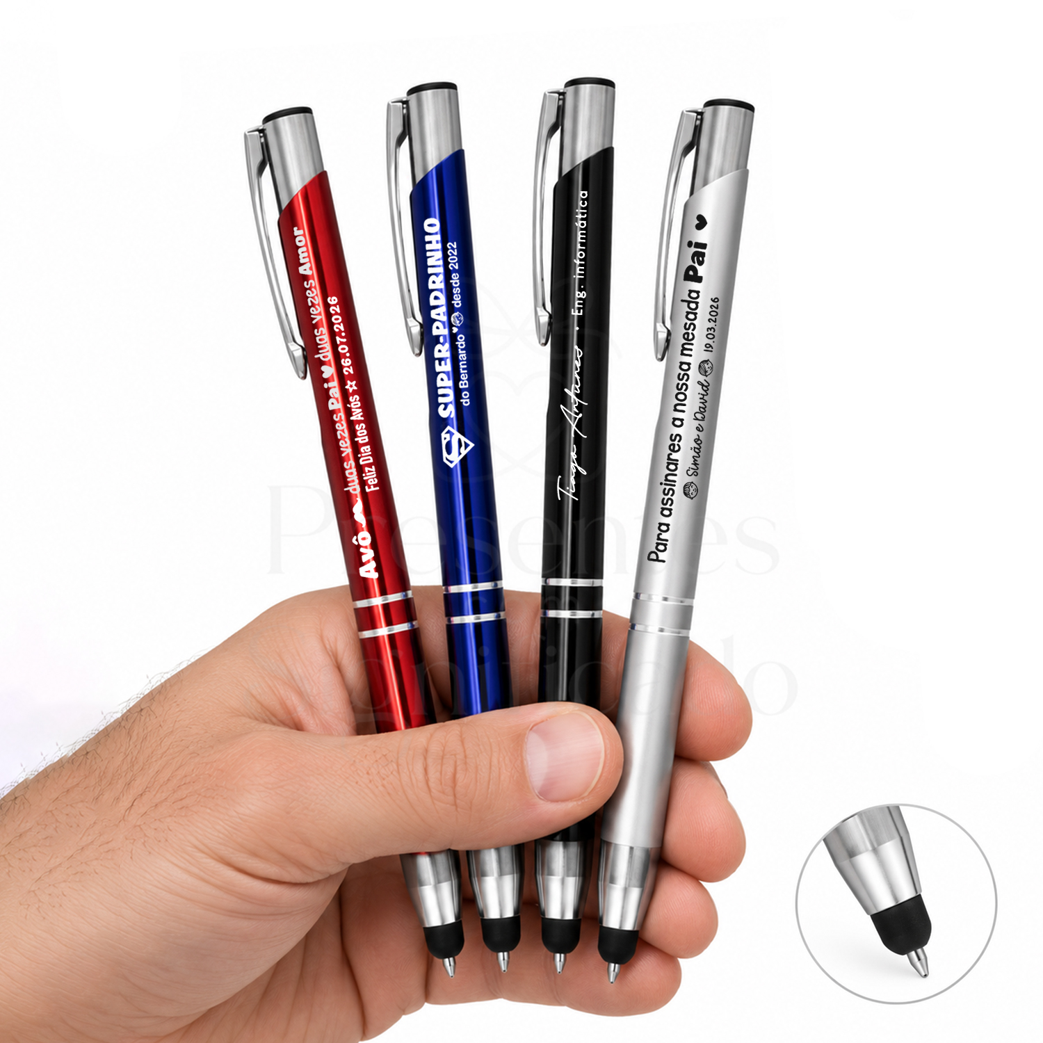 Caneta Personalizada em Alumínio com Ponta Touch e Dois Anéis Quatro canetas metálicas coloridas com textos personalizados em português numa mão branca num fundo branco