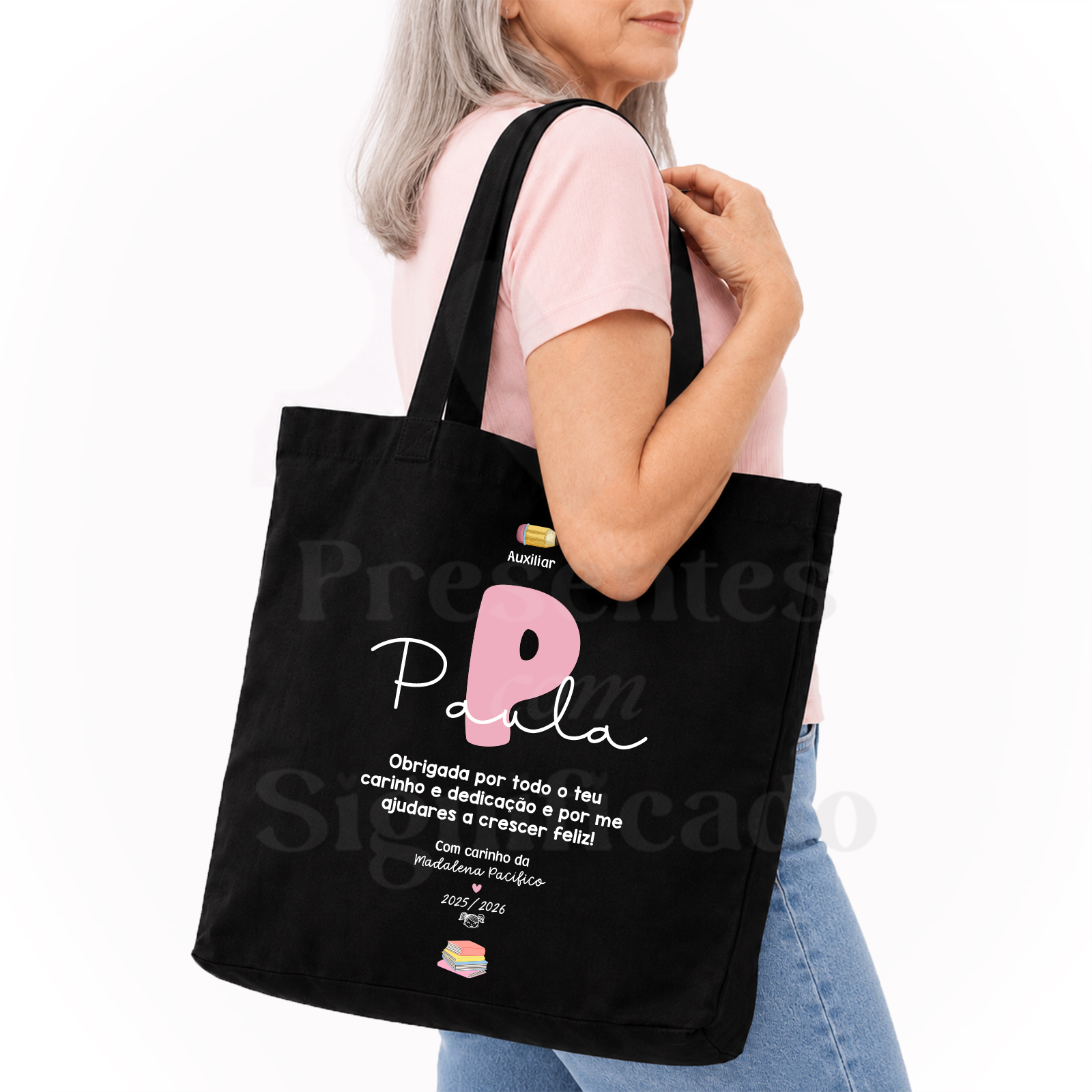 Saco/tote bag Mulher com sacola preta de tecido com texto personalizado em branco e rosa e pequenos ícones coloridos.