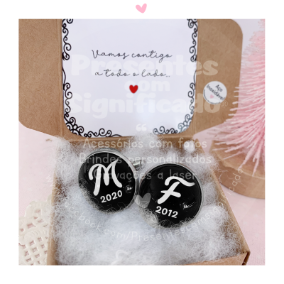 Conjunto de botões pretos com letras brancas em caixa com cartão e enchimento