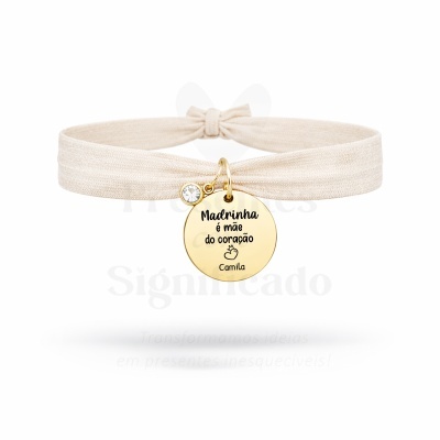 Pulseira elástica bege com pendente redondo dourado gravado