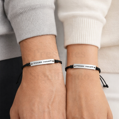 Duas pulseiras com placa metálica gravada e cordão preto