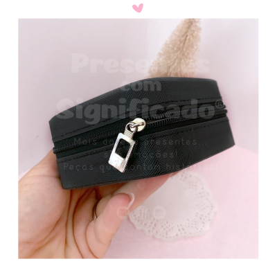 Mala pequena circular preta com fecho prateado em fundo rosa