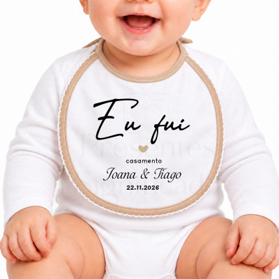 Babete branco com bordas bege e texto preto usado por bebé sorridente