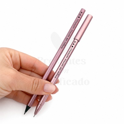 Caneta e lápis rosa velho com texto em português segurados numa mão