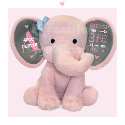 Peluche elefante cor-de-rosa com informações de nascimento nas orelhas.