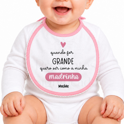 Babete branco com rebordo rosa e texto impresso usado por bebé