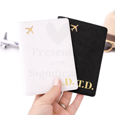 Dois porta-passaportes branco e preto com símbolo dourado de avião e iniciais