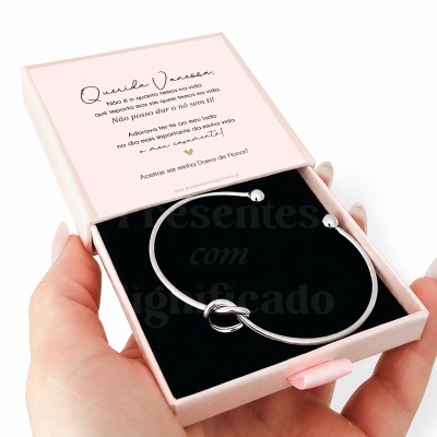 Pulseira de nó prateada em caixa rosa com mensagem personalizada em português.